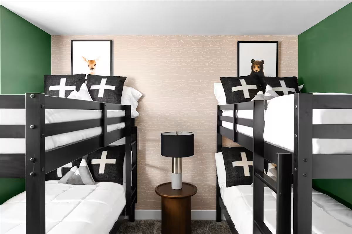 Bunk room with two sets of black bunk beds and playful artwork